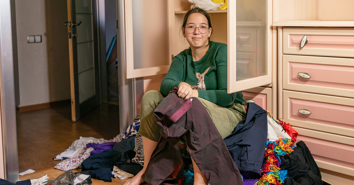 A girl sorts clothing wishing organizing was more joyous
